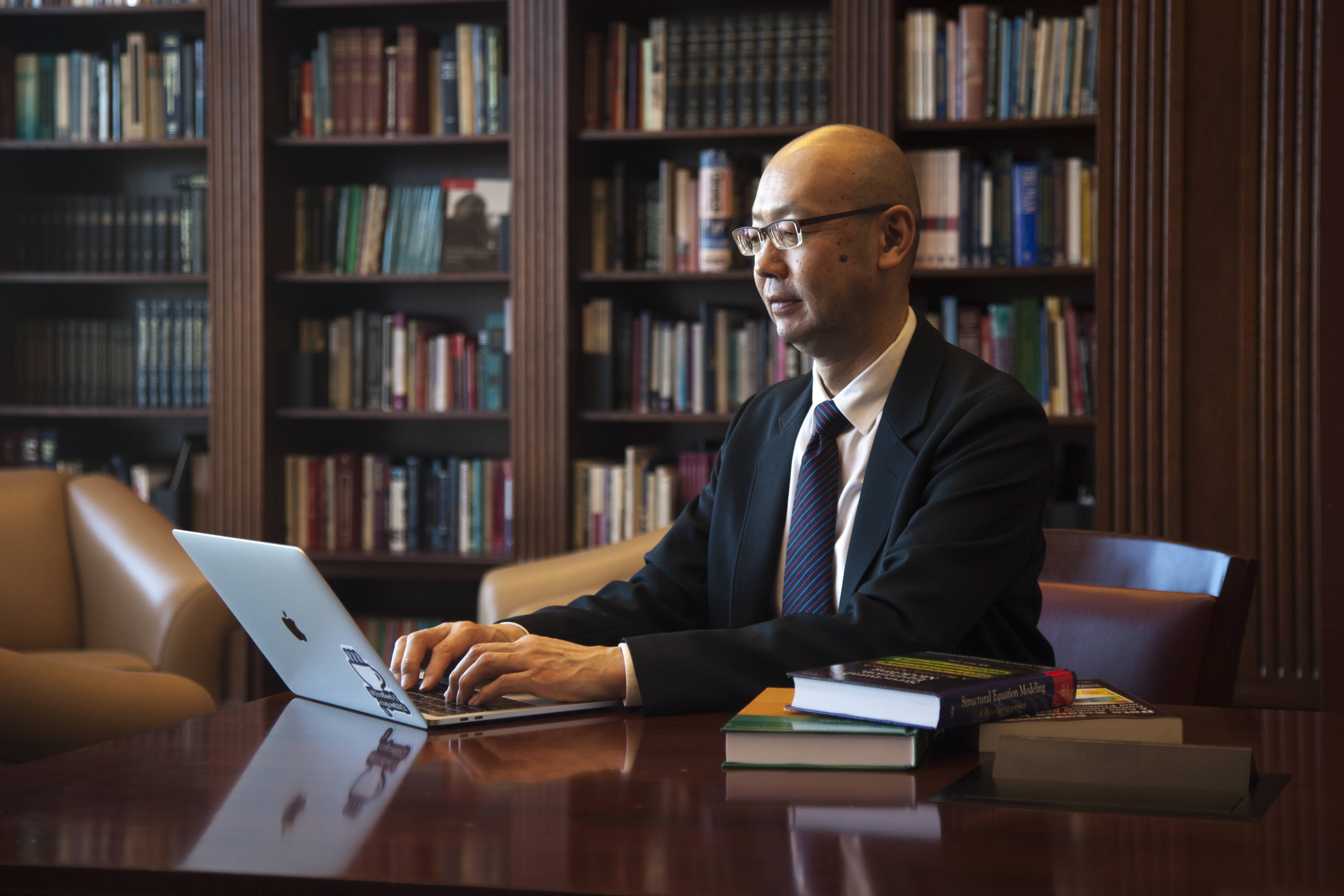 professor sitting at table on laptop
