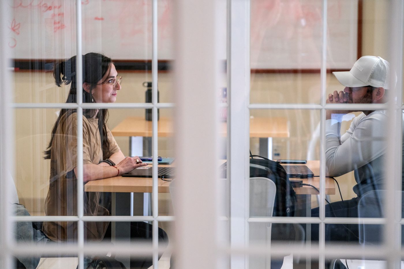 Looking through the glass at students collaborating
