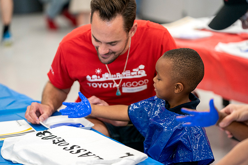 A person and child fingerpaint at the West Dallas STEM school
